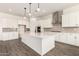 Modern kitchen features a large center island, stainless steel hood, and white cabinetry and countertops at 20255 W Monterey Way, Buckeye, AZ 85396