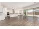 An open-concept living room with tile flooring, a large kitchen, and access to the patio at 20255 W Monterey Way, Buckeye, AZ 85396