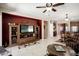 Spacious living room featuring entertainment center, ceiling fan, access to the dining room and great natural light at 20523 N 267Th Ln, Buckeye, AZ 85396