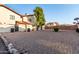Exterior side of a home with a sprawling gravel yard, trash cans, and a privacy fence at 2431 E Tracy Ln # 1, Phoenix, AZ 85032