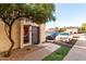 Condo entrance featuring a security door, mature tree, well-maintained desert landscaping, and ample parking at 2431 E Tracy Ln # 1, Phoenix, AZ 85032