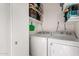 Efficient laundry room equipped with a washer, dryer, and storage shelves at 2431 E Tracy Ln # 1, Phoenix, AZ 85032