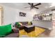 Inviting living room featuring a comfortable couch, stylish yellow rug, and modern ceiling fan at 2431 E Tracy Ln # 1, Phoenix, AZ 85032