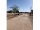 Gravel driveway leading to gated rural property on a sunny day at 2637 S Amanda Dr, Maricopa, AZ 85139