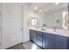 Elegant bathroom featuring dual sinks, a large mirror, and stylish gray cabinetry at 27053 W Ponderosa Ln, Buckeye, AZ 85396