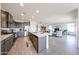 Open concept kitchen with quartz counters, stainless appliances, and wood plank floors at 27053 W Ponderosa Ln, Buckeye, AZ 85396