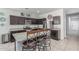 Kitchen with granite countertops, dark cabinetry, and a center island with seating at 30954 W Whitton Ave, Buckeye, AZ 85396