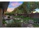 This backyard features a cozy patio with built in grill, lush landscaping and a pond at 315 E Marlette Ave, Phoenix, AZ 85012