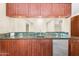Bar area with wooden cabinets, granite countertop, stainless steel mini-fridge, and sink at 315 E Marlette Ave, Phoenix, AZ 85012