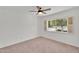 Bright bedroom with neutral carpet and a ceiling fan, illuminated by natural light from the large window at 315 E Marlette Ave, Phoenix, AZ 85012