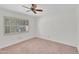 Bedroom featuring neutral carpeting, a ceiling fan, and window with views of the neighborhood at 315 E Marlette Ave, Phoenix, AZ 85012