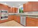 Well-lit kitchen boasts wooden cabinets, granite countertops, and stainless steel appliances at 315 E Marlette Ave, Phoenix, AZ 85012
