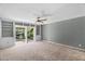 Bright living room with built in shelving and a ceiling fan, as well as a sliding glass door, leading to a beautiful yard at 315 E Marlette Ave, Phoenix, AZ 85012