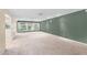Spacious living room featuring neutral carpet, green accent wall, and natural light from large windows overlooking the backyard at 315 E Marlette Ave, Phoenix, AZ 85012