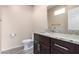 Bathroom featuring granite countertop, updated fixtures, dark wood cabinetry, and a toilet at 34710 N 27Th Ave, Phoenix, AZ 85086