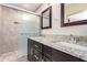 Bathroom featuring dual sinks, granite countertops, dark wood cabinetry, and a tiled walk-in shower at 34710 N 27Th Ave, Phoenix, AZ 85086