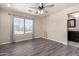 This bedroom features wood-look floors, a ceiling fan, and a large window for ample natural light at 34710 N 27Th Ave, Phoenix, AZ 85086