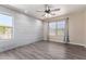 Bedroom with a white-washed accent wall, wood-look flooring and ceiling fan at 34710 N 27Th Ave, Phoenix, AZ 85086