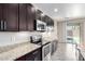 Kitchen area showcasing granite countertops, a stainless-steel oven, and dark wood cabinetry at 34710 N 27Th Ave, Phoenix, AZ 85086