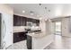 Modern kitchen featuring a granite island, stainless steel appliances, and dark wood cabinetry at 34710 N 27Th Ave, Phoenix, AZ 85086