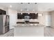 Modern kitchen featuring wood cabinets, stainless appliances and a center island with pendant lighting at 34710 N 27Th Ave, Phoenix, AZ 85086