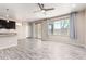 Bright living room featuring light wood floors, a ceiling fan, and large windows with backyard views at 34710 N 27Th Ave, Phoenix, AZ 85086