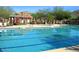 Sparkling community pool with lane markers and lounge chairs with mountain views and desert landscaping at 34710 N 27Th Ave, Phoenix, AZ 85086