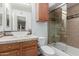 Bright bathroom features a glass bowl sink, wood cabinets, and a shower-tub combo at 3526 N 85Th St, Scottsdale, AZ 85251
