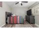 Cozy bedroom features stylish quilt, wood-look flooring, modern ceiling fan, and a dresser with a TV at 3526 N 85Th St, Scottsdale, AZ 85251