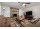 Inviting living room with stone fireplace, ceiling fan, and plank flooring at 3526 N 85Th St, Scottsdale, AZ 85251
