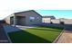 Landscaped backyard with synthetic grass, a paved patio, block wall fencing, and a covered patio at 37049 N Lokai Dr, San Tan Valley, AZ 85140
