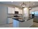 Bright kitchen with white cabinets, a granite island, stainless steel appliances, and modern pendant lighting at 37049 N Lokai Dr, San Tan Valley, AZ 85140