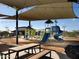 Community playground featuring slides, covered seating areas, and ample space for recreational activities at 37049 N Lokai Dr, San Tan Valley, AZ 85140