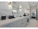 Double sink bathroom featuring stylish mirror, marble walls, and modern lighting fixtures at 37200 N Cave Creek Rd # 1013, Scottsdale, AZ 85262