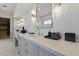 Double sink bathroom featuring stylish mirror, marble walls, and modern lighting fixtures at 37200 N Cave Creek Rd # 1013, Scottsdale, AZ 85262