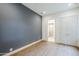 Bright bedroom with wood flooring, grey accent wall, double closet doors, and open door to the bathroom at 37200 N Cave Creek Rd # 1013, Scottsdale, AZ 85262