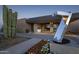 Landscaped entrance featuring modern architecture, flowers, and a sculpture at 37200 N Cave Creek Rd # 1013, Scottsdale, AZ 85262