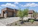 Modern home with desert landscaping featuring native plants and a spacious driveway leading to a multi-car garage at 37200 N Cave Creek Rd # 1013, Scottsdale, AZ 85262