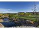 Scenic golf course view featuring a tranquil pond, lush greenery, and distant mountain backdrop at 37200 N Cave Creek Rd # 1013, Scottsdale, AZ 85262