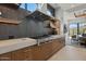 Modern kitchen with stainless steel range hood, gray backsplash, and chef-style gas cooktop at 37200 N Cave Creek Rd # 1013, Scottsdale, AZ 85262