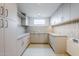 Modern laundry room with neutral color scheme, stylish tile backsplash, ample cabinet space, and sleek countertops at 37200 N Cave Creek Rd # 1013, Scottsdale, AZ 85262