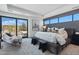 The primary bedroom features a large bed, seating area, and floor to ceiling glass doors at 37200 N Cave Creek Rd # 1013, Scottsdale, AZ 85262