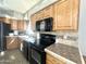 Bright kitchen features wood cabinets, black appliances, and tile backsplash at 381 S Gypsum Dr, Apache Junction, AZ 85119