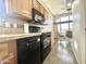 Bright kitchen features tile floor, wood cabinets, and black appliances at 381 S Gypsum Dr, Apache Junction, AZ 85119