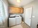 Bright laundry room with window, wooden cabinets, and a modern washer and dryer set at 381 S Gypsum Dr, Apache Junction, AZ 85119