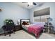 Comfortable bedroom with desk, ceiling fan and neutral carpet with window overlooking the backyard at 3841 E Patrick Ln, Phoenix, AZ 85050