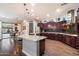 Gourmet kitchen with island, granite counters, stainless appliances, and dark wood cabinetry at 3841 E Patrick Ln, Phoenix, AZ 85050