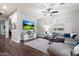 Cozy living room with neutral colors, ceiling fan, and a large television at 3841 E Patrick Ln, Phoenix, AZ 85050