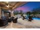 Inviting outdoor patio with built-in grill, ample seating, and views of a sparkling pool at dusk at 3841 E Patrick Ln, Phoenix, AZ 85050