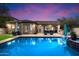 Backyard view showcasing a pristine pool, covered patio, outdoor kitchen, and lush landscaping for ultimate outdoor living at 3841 E Patrick Ln, Phoenix, AZ 85050